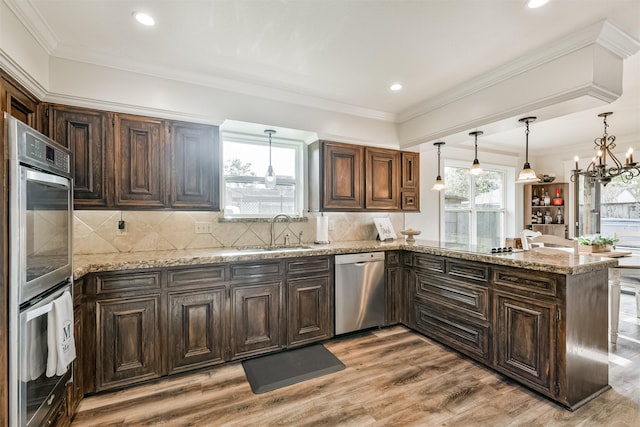 kitchen featuring sink, an inviting chandelier, tasteful backsplash, light hardwood / wood-style flooring, and stainless steel dishwasher