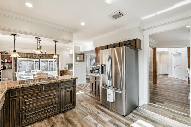 kitchen featuring stainless steel fridge, light stone counters, dark brown cabinets, crown molding, and light hardwood / wood-style floors