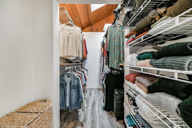 spacious closet featuring vaulted ceiling with skylight and wood-type flooring