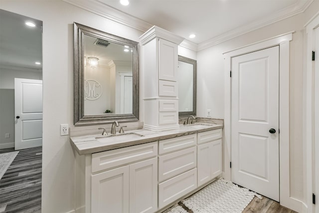 bathroom featuring crown molding, vanity, and wood-type flooring