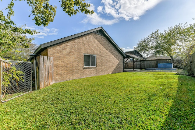 view of home's exterior with a yard and a hot tub