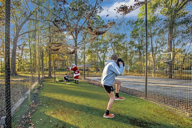 view of home's community with a lawn and basketball hoop