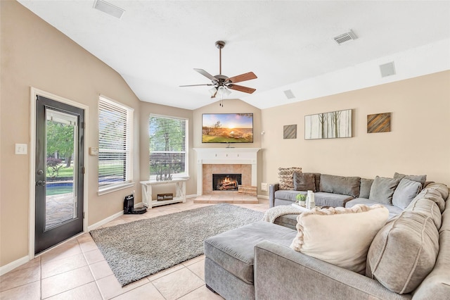 living room featuring ceiling fan, light tile patterned flooring, lofted ceiling, and a fireplace