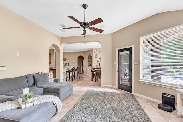 living room with light tile patterned floors, vaulted ceiling, and ceiling fan