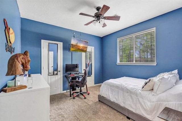 carpeted bedroom with ceiling fan and a textured ceiling