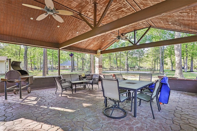 sunroom / solarium with vaulted ceiling with beams, ceiling fan, and a wealth of natural light