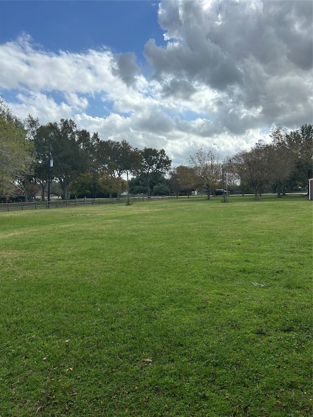 view of property's community featuring a lawn and a rural view