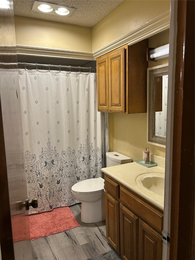 bathroom featuring hardwood / wood-style floors, vanity, a textured ceiling, and toilet