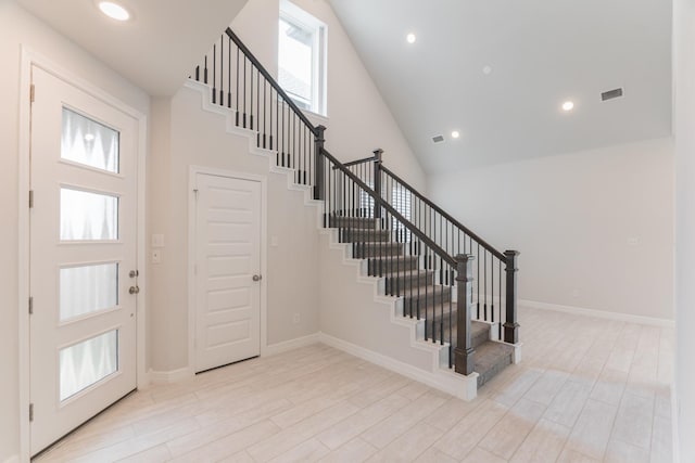 foyer entrance with a high ceiling and light wood-type flooring