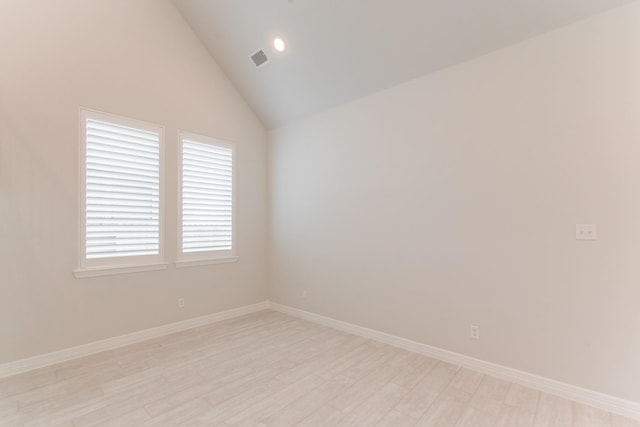 unfurnished room with light hardwood / wood-style floors and vaulted ceiling