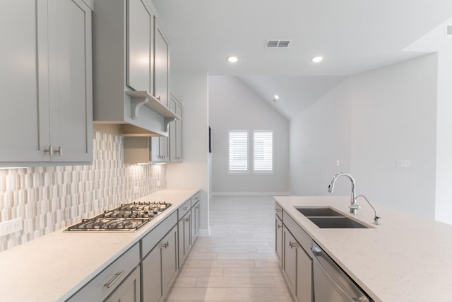 kitchen featuring sink, backsplash, appliances with stainless steel finishes, and gray cabinets