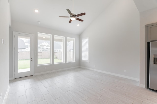 unfurnished living room with ceiling fan and high vaulted ceiling