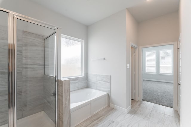 bathroom with plenty of natural light and separate shower and tub