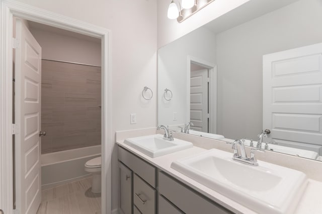 full bathroom with toilet, vanity, and tiled shower / bath