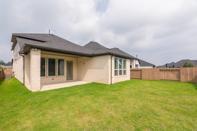 rear view of property featuring a lawn and a patio