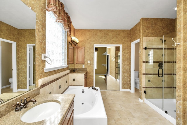 full bathroom with tile patterned floors, vanity, shower with separate bathtub, and toilet