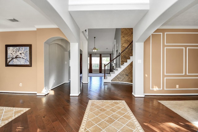 foyer entrance featuring ceiling fan, ornamental molding, and dark wood-type flooring