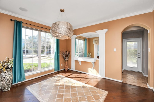 unfurnished dining area featuring decorative columns, crown molding, and dark hardwood / wood-style floors