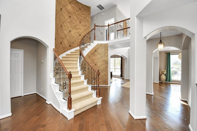 entrance foyer with dark hardwood / wood-style floors and a high ceiling