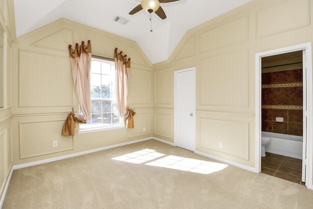 unfurnished bedroom with connected bathroom, ceiling fan, carpet, and vaulted ceiling