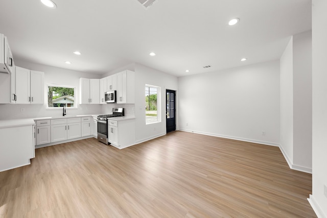 kitchen featuring light hardwood / wood-style floors, white cabinetry, sink, and appliances with stainless steel finishes