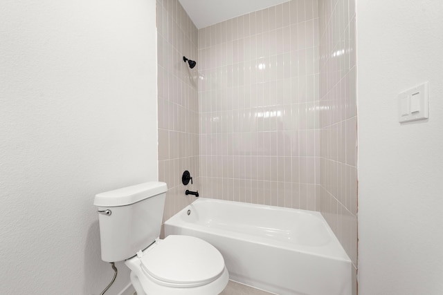 bathroom featuring toilet and tiled shower / bath