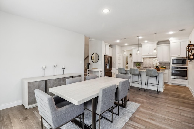 dining space with light hardwood / wood-style flooring