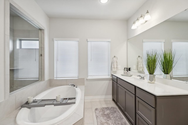 bathroom featuring vanity and tiled bath