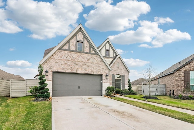 tudor home with a front yard and a garage