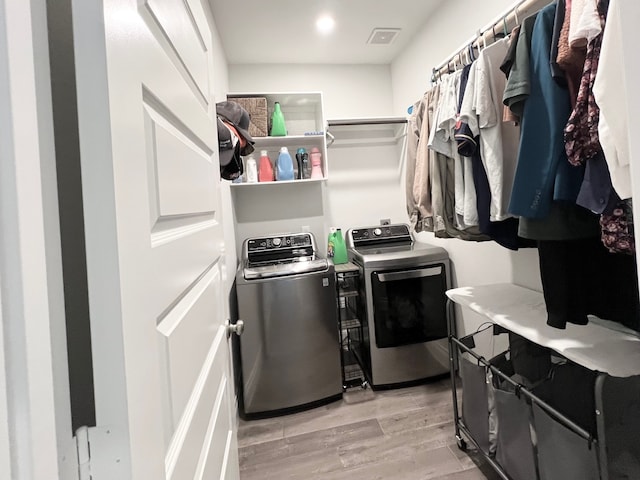 washroom with light hardwood / wood-style floors and independent washer and dryer