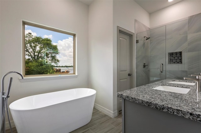 bathroom with hardwood / wood-style floors, vanity, and shower with separate bathtub