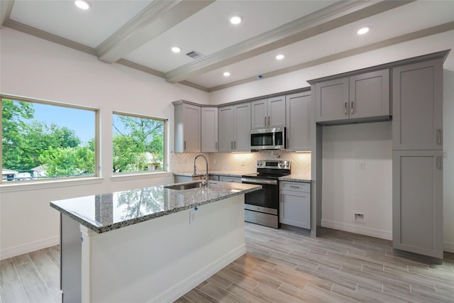 kitchen with sink, light hardwood / wood-style flooring, gray cabinets, appliances with stainless steel finishes, and light stone counters