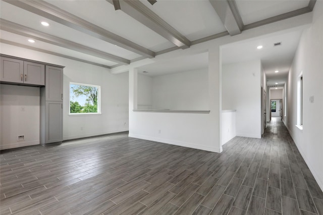 unfurnished living room with beamed ceiling and dark hardwood / wood-style flooring