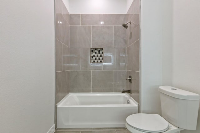 bathroom featuring tiled shower / bath combo and toilet