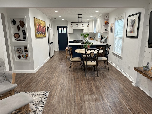 dining area with a textured ceiling and dark wood-type flooring