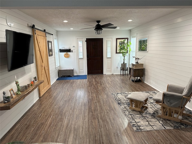 foyer entrance featuring plenty of natural light, a barn door, dark hardwood / wood-style flooring, and a textured ceiling