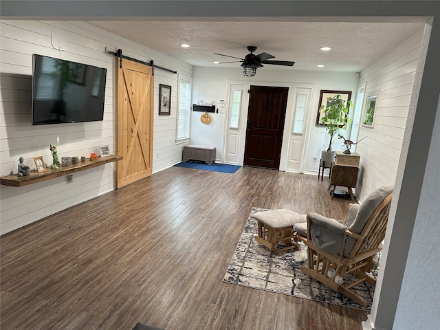 living room featuring dark hardwood / wood-style floors, a barn door, and a textured ceiling