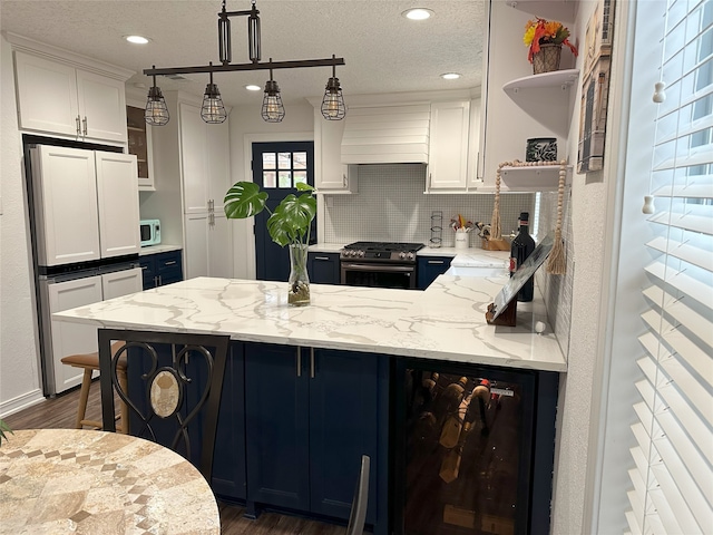 kitchen featuring light stone counters, white cabinets, beverage cooler, and white appliances