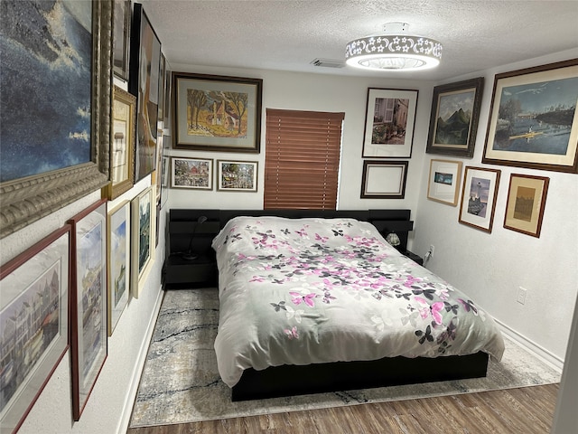 bedroom featuring hardwood / wood-style floors and a textured ceiling