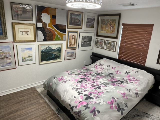 bedroom with dark hardwood / wood-style flooring and a textured ceiling