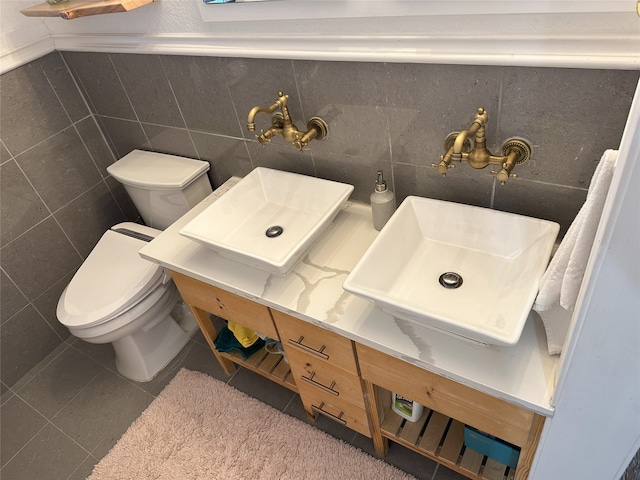 bathroom featuring toilet, tile walls, and sink