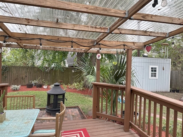 wooden terrace featuring a shed and a yard