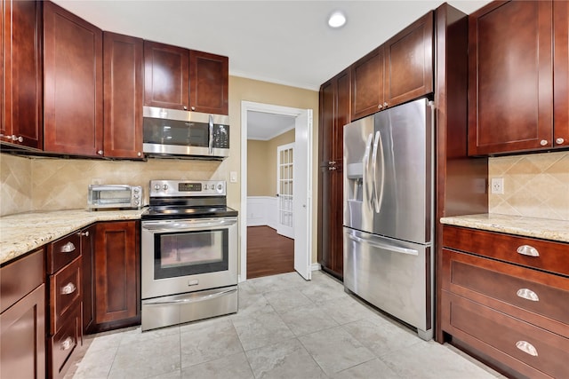 kitchen with backsplash, light stone countertops, crown molding, and stainless steel appliances