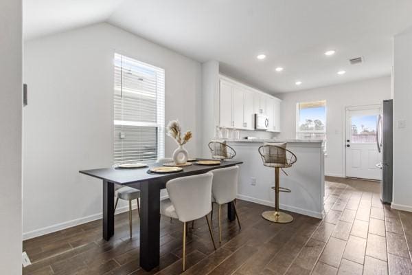 dining room with dark hardwood / wood-style floors and vaulted ceiling