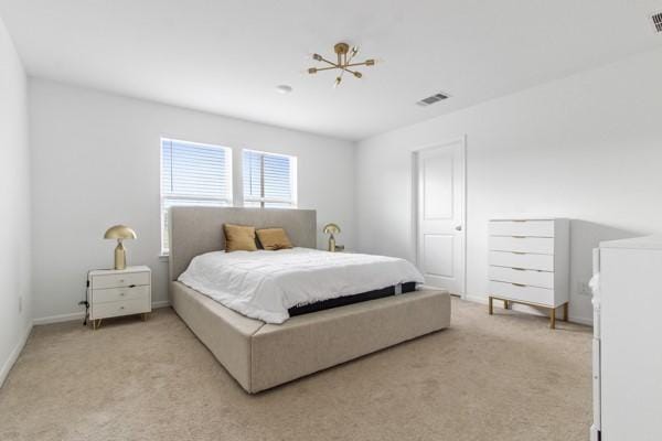 carpeted bedroom featuring an inviting chandelier