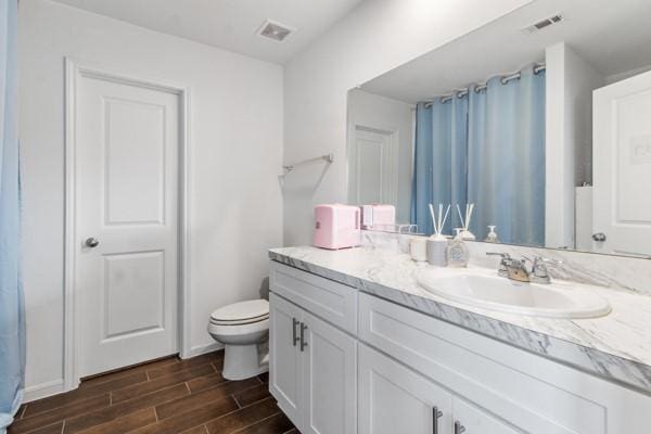 bathroom featuring hardwood / wood-style flooring, vanity, and toilet