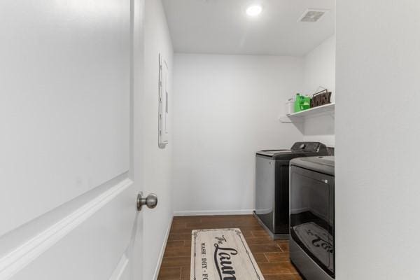 laundry room featuring washer and dryer and dark hardwood / wood-style floors