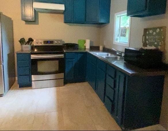 kitchen featuring blue cabinetry, exhaust hood, stainless steel appliances, and sink