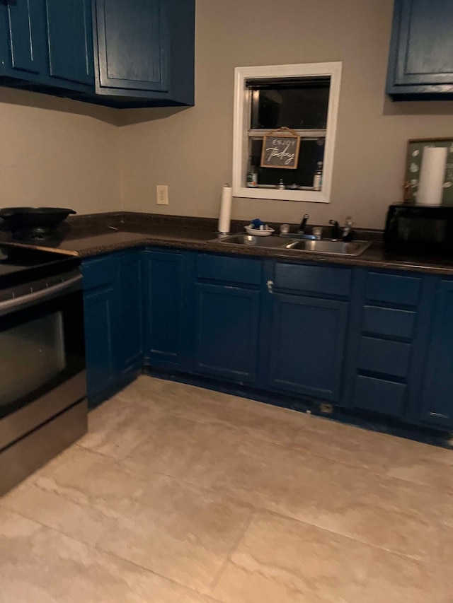 kitchen with sink, light tile patterned floors, stainless steel electric range, and blue cabinets