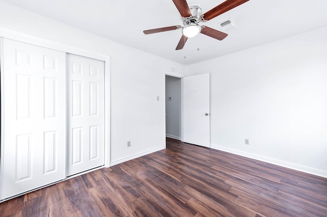 unfurnished bedroom featuring ceiling fan, a closet, and dark wood-type flooring